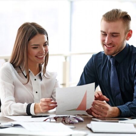 Professional man and woman in business attire discussing a document, symbolizing successful consultant hiring for a Dallas firm, as highlighted in our case study.